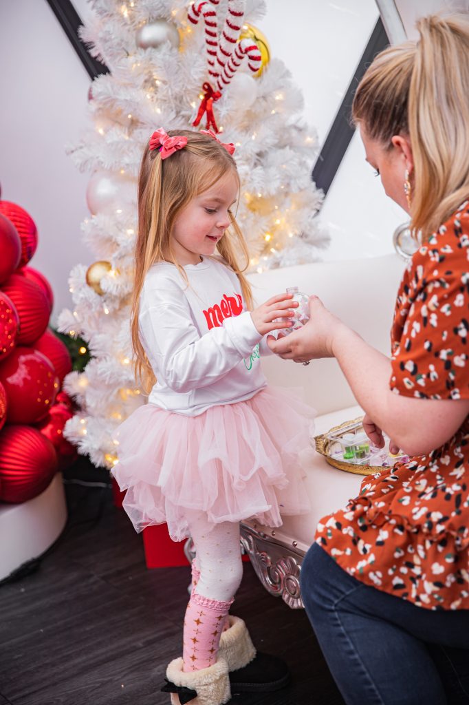 Nicki Odom with daughters make magic wands at Candy Cane Christmas tea party making a DIY ornament
