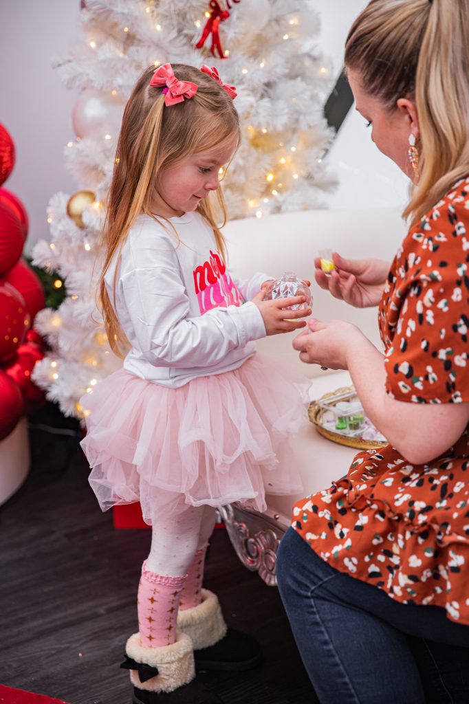 Nicki Odom with daughters make magic wands at Candy Cane Christmas tea party making a DIY ornament