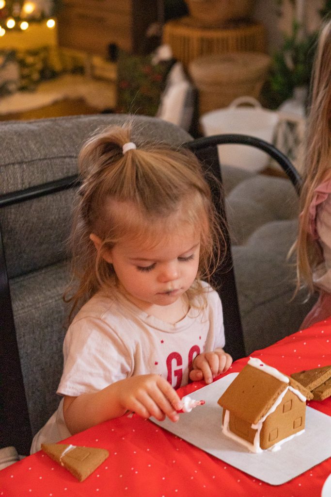 Nicki Odom's daughter making gingerbread house at Christmas party