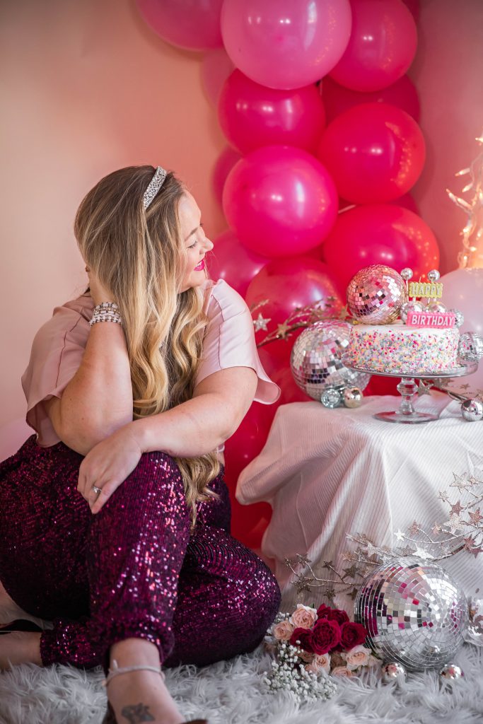 Birthday photoshoot with disco balls for Nicki Odom's 35th Birthday wearing plum sequin joggers and disco ball decorations How To Face Your Fears in 2023
