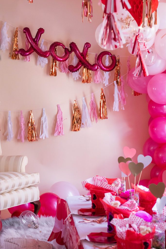 Galentine's day setup with XoXo mylar balloons, valentine's day garland and hot pink balloons