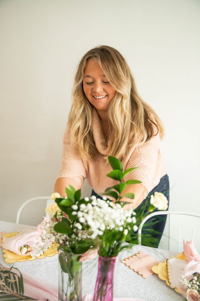 Nicki Odom setting a table for hosting a dinner party