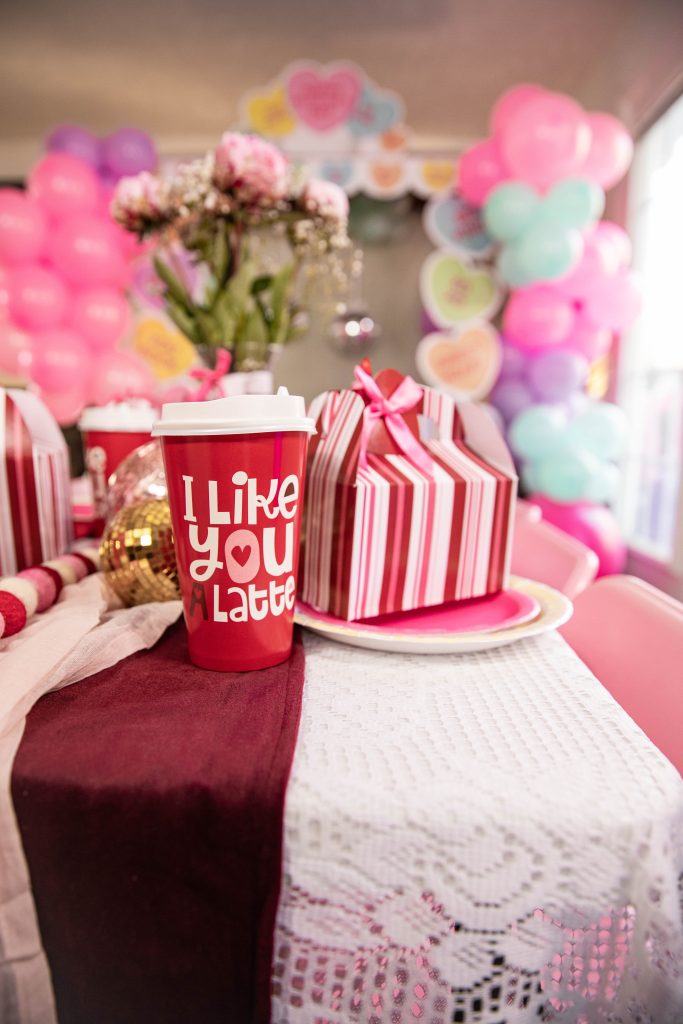 Galentines Day Make and Take DIY Craft Party with balloon arches and conversation hearts with Valentine's day table decorations