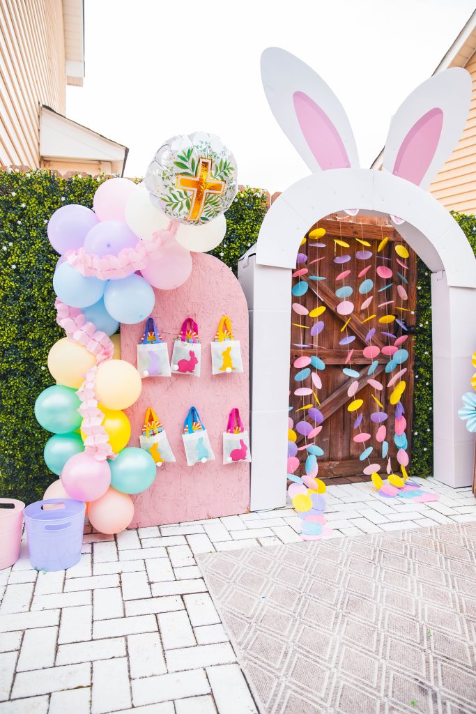 Spring 'He Is Risen' Easter Celebration photo backdrop with bunny ears and gift bags