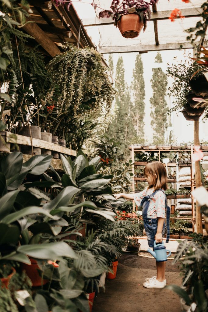 Young girl in a greenhouse with plants