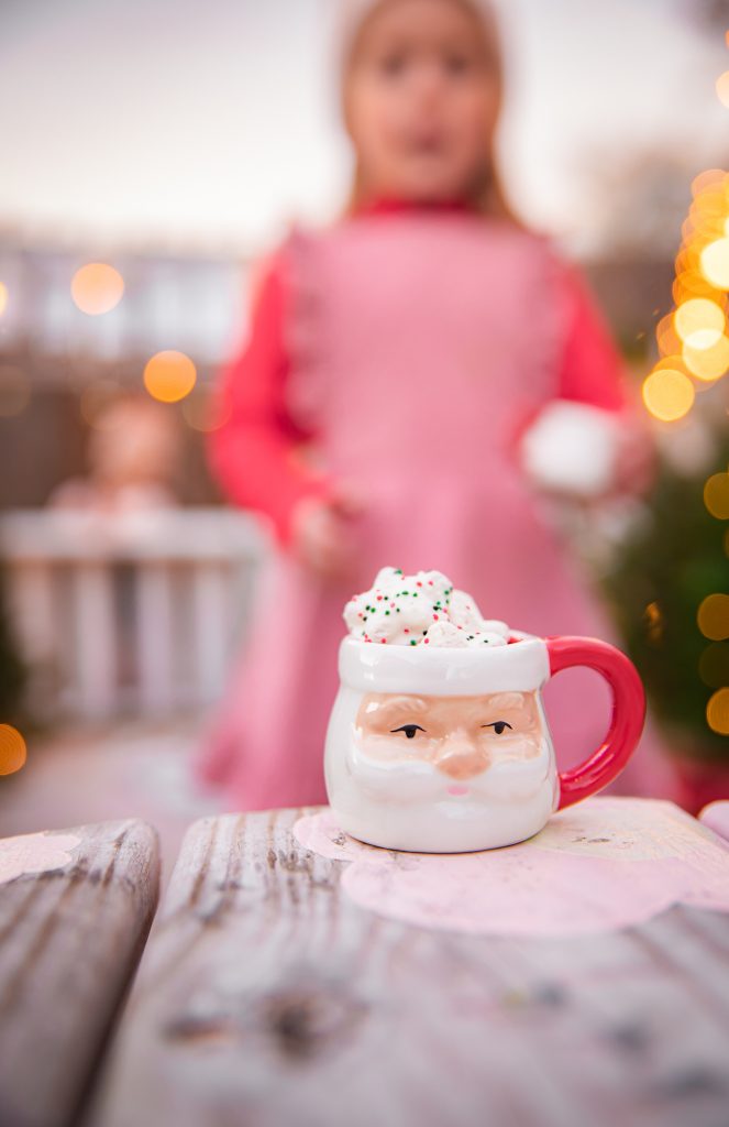Kids Christmas Tree Farm Photoshoot - Nicki Odom's daughter drinking hot chocolate in Santa Claus mini mug