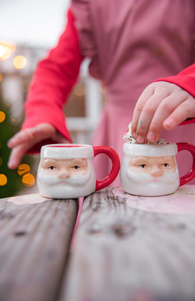 Kids Christmas Tree Farm Photoshoot - Nicki Odom's daughter drinking hot chocolate in Santa Claus mini mug