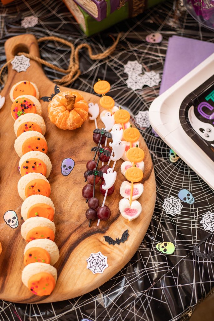 Halloween snack table with fruit and cookies charcuterie board