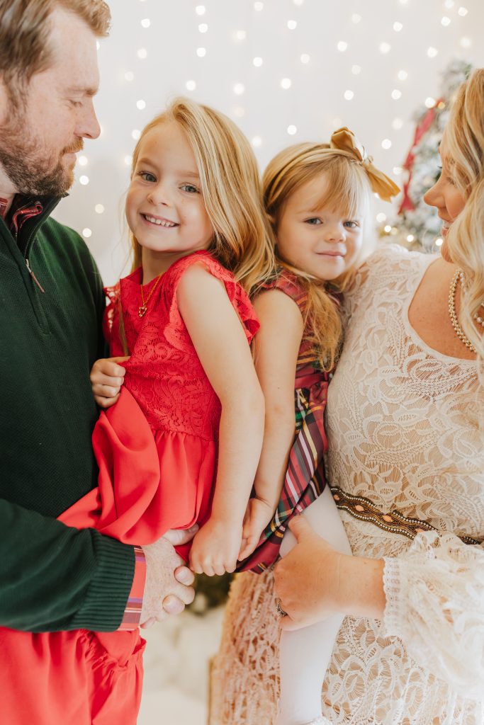 Nicki Odom and family beside Christmas trees
