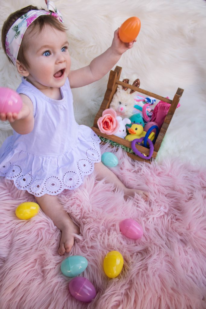 Toddler Girl Opening Easter Eggs by her Easter Basket