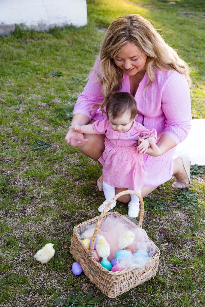 Mom and baby by Easter basket in the grass