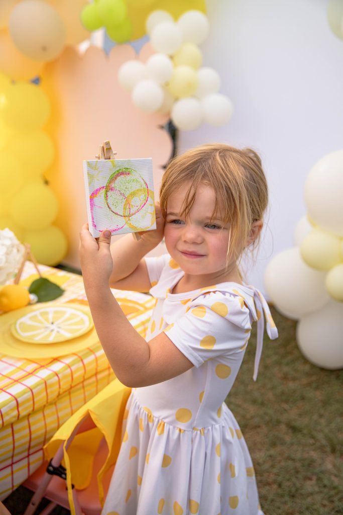 girl holding her canvas at Kids Citrus Art Summer Activity party