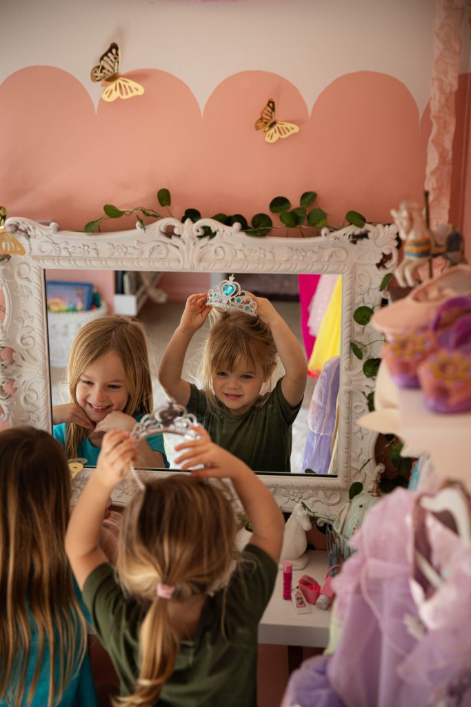 two girls looking in vanity mirror in Disney Princess bedroom