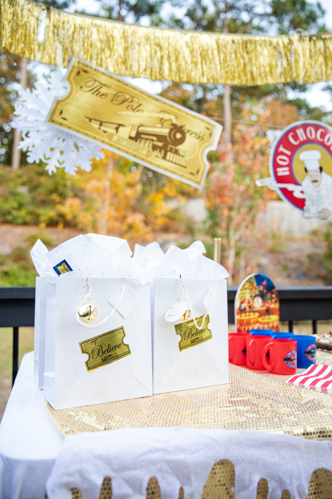 Polar Express Believe golden ticket stickers with gifts on table for Polar Express Movie night party